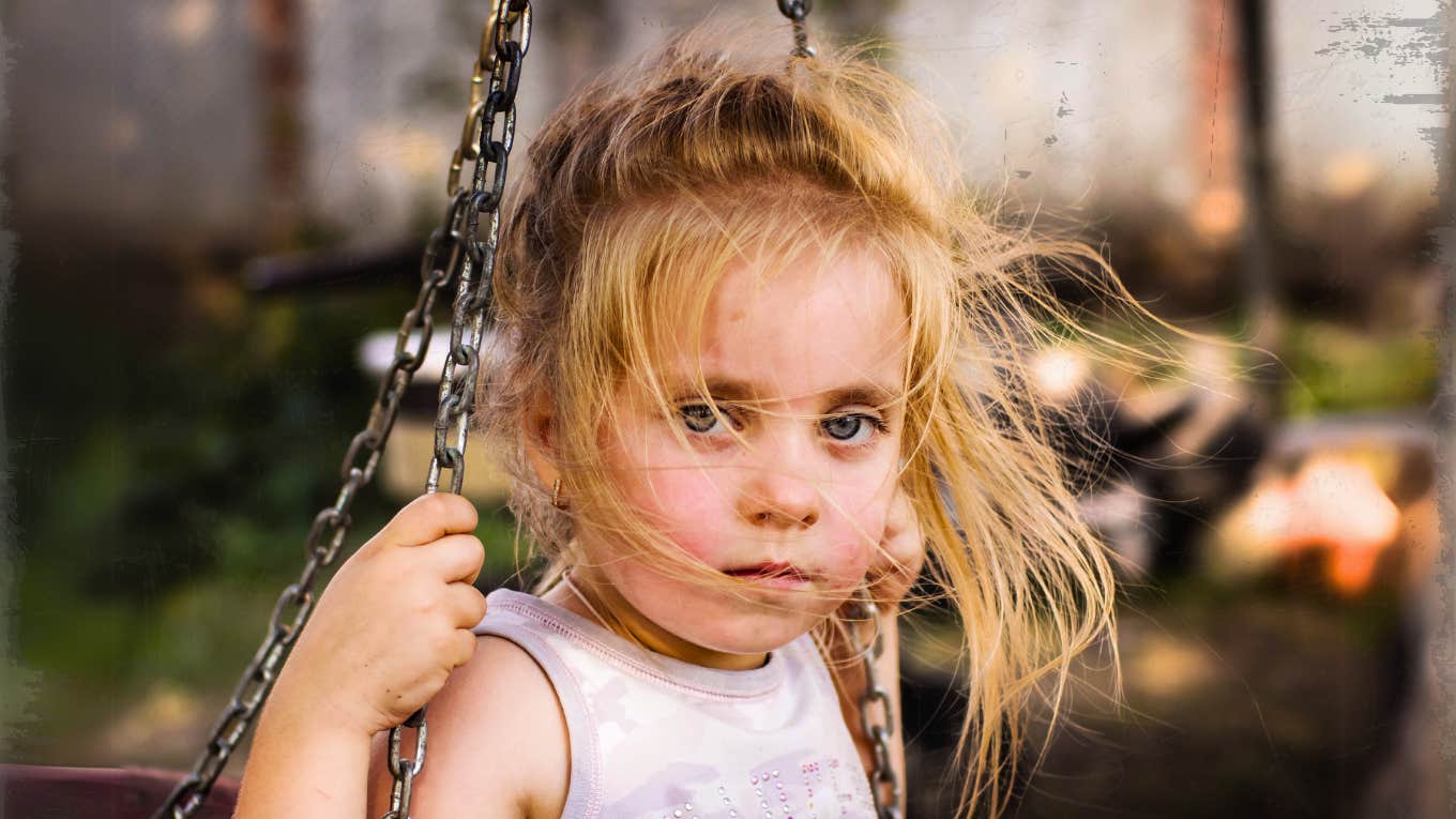 Poor American girl on a swing outside