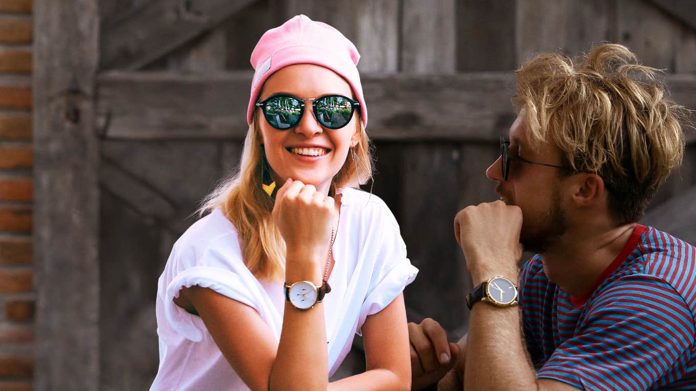 Woman smiling, man looking at her while working on a healthier relationship