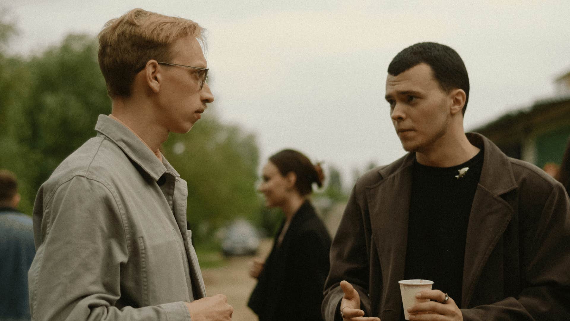 two men talking holding coffee