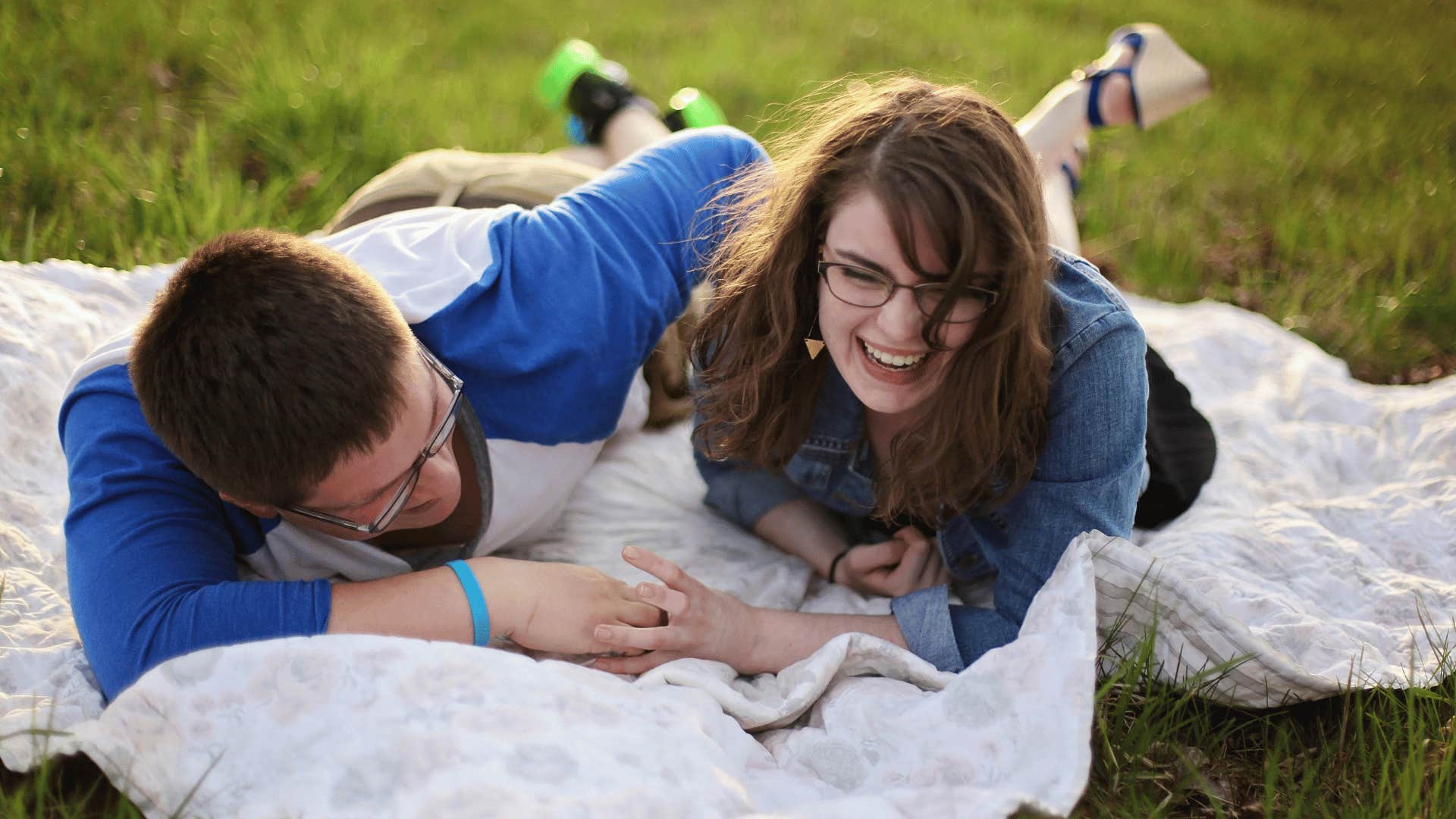 a couple laying on blanket laughing 