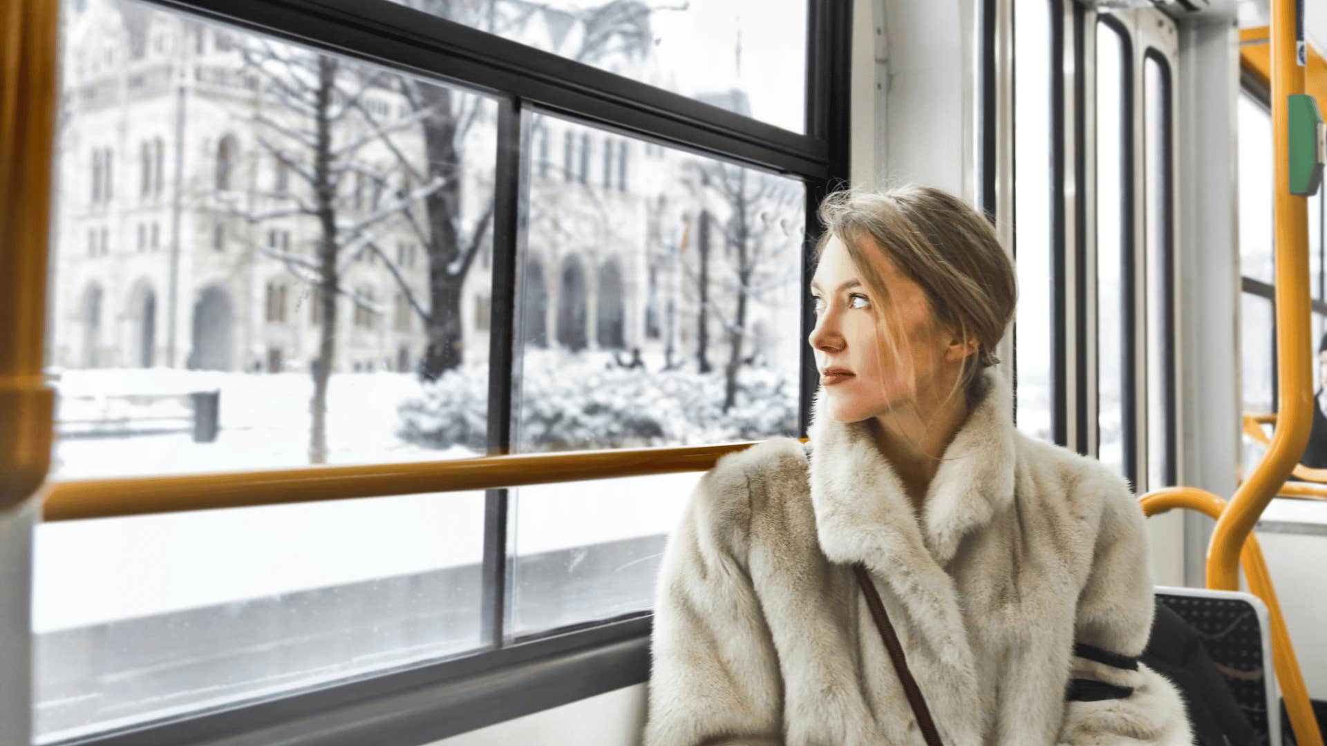 woman staring out window reflecting 