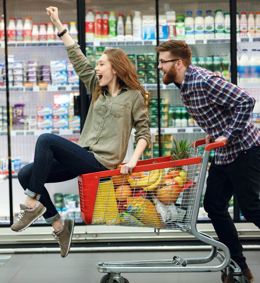 Happy couple with extra money grocery shopping