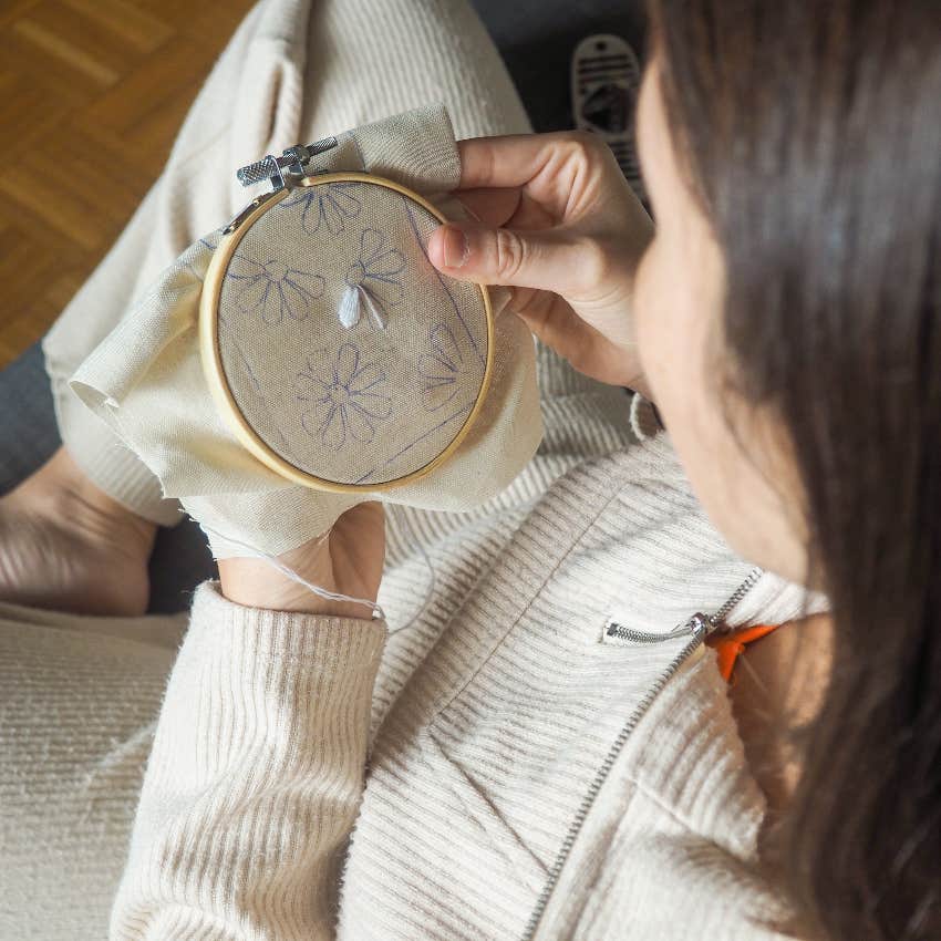 Introverted woman doing embroidery, a cozy hobby