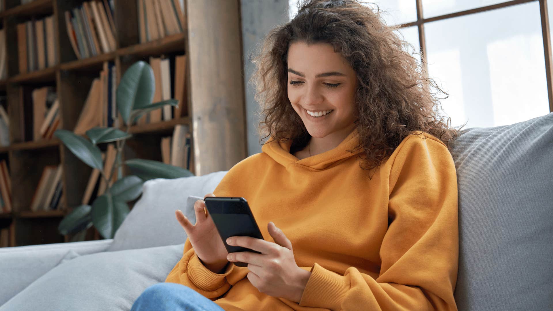 woman smiling at phone sitting down