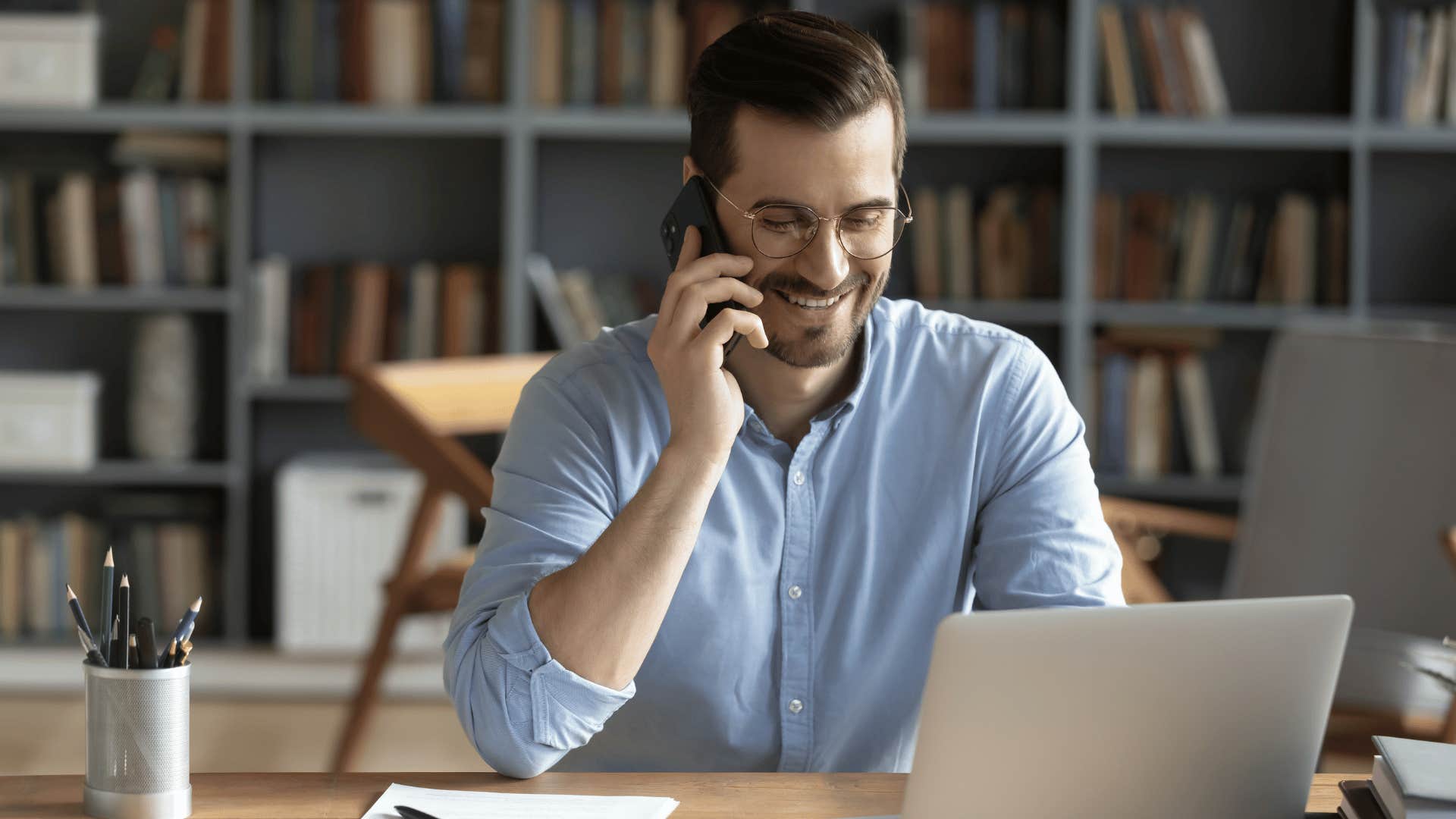 man speaking on the phone at job while smiling