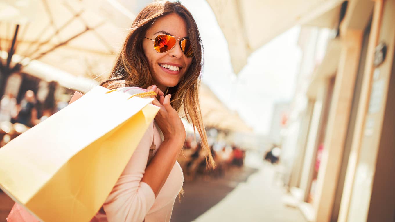 happy, smiling woman carrying shopping bags