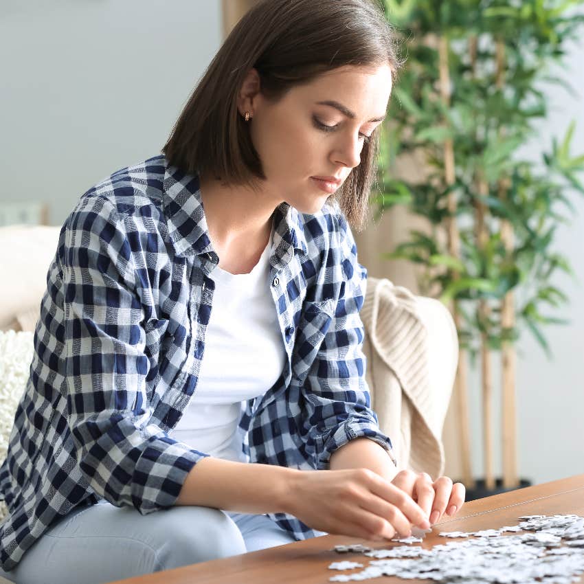 Introverted woman doing a puzzle, cozy hobby