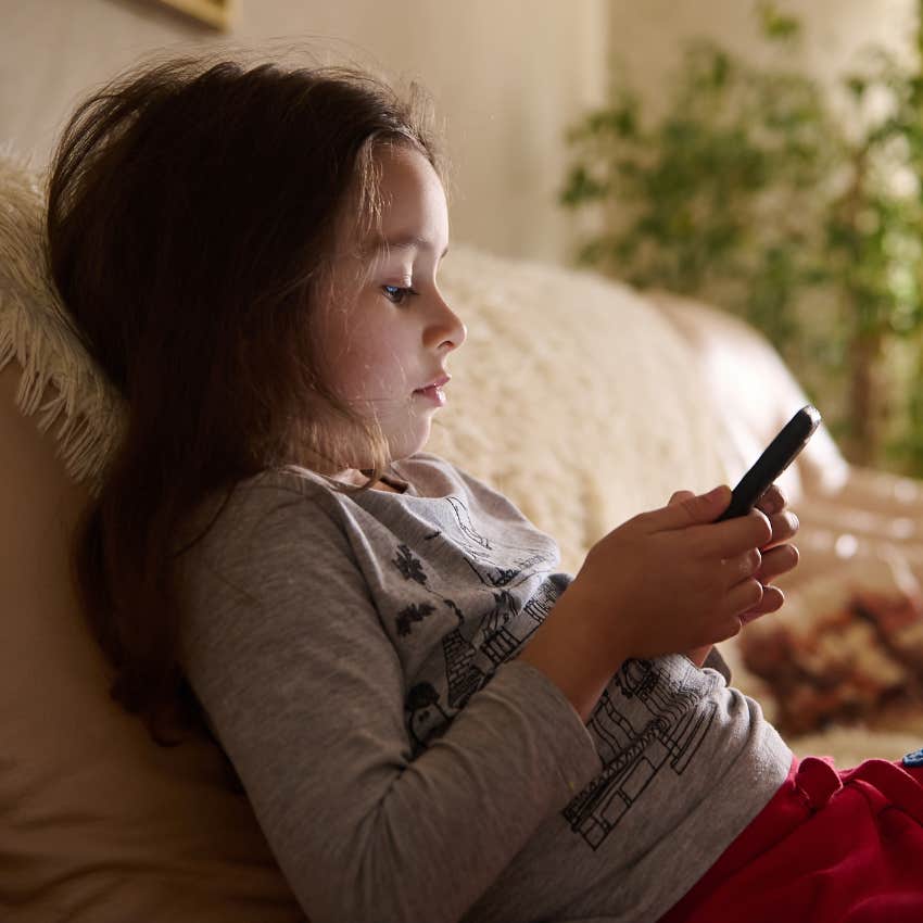 Young girl playing on her phone without a babysitter.