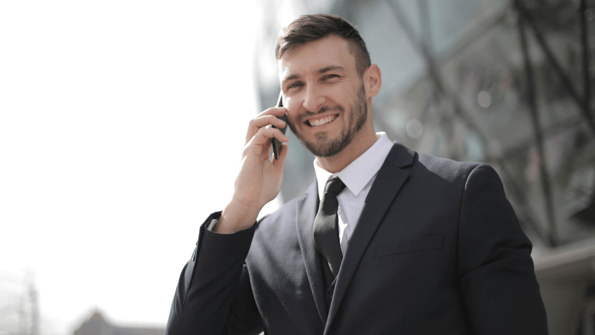 man smiling while on the phone