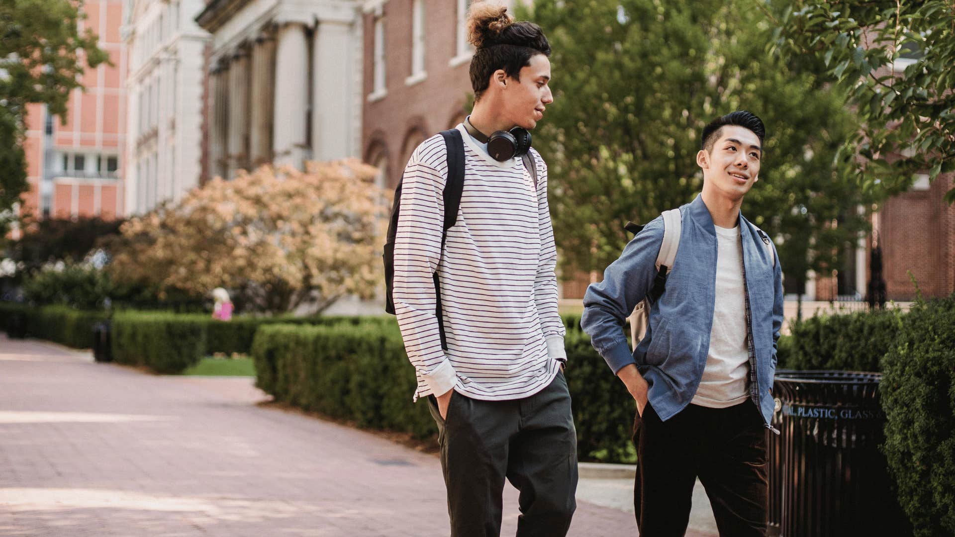 two friends walking beside each other talking 