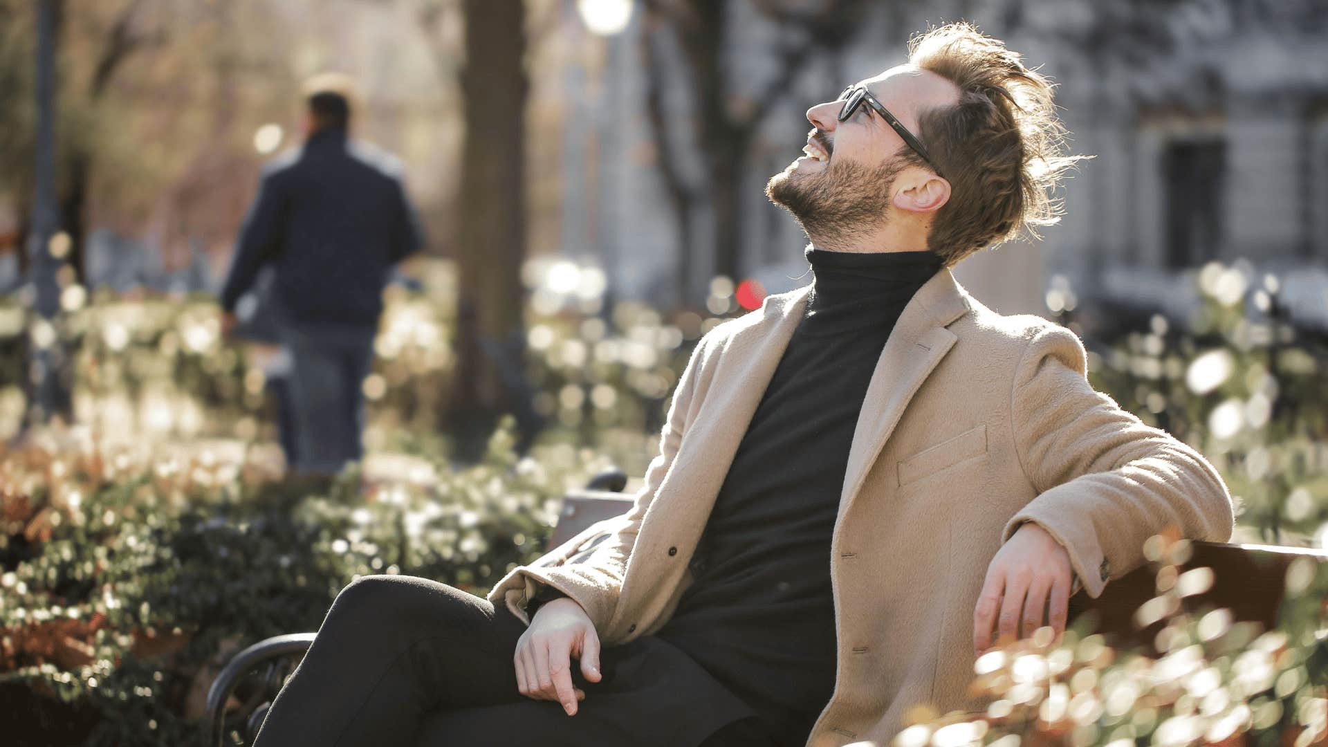 man sitting on bench looking up 