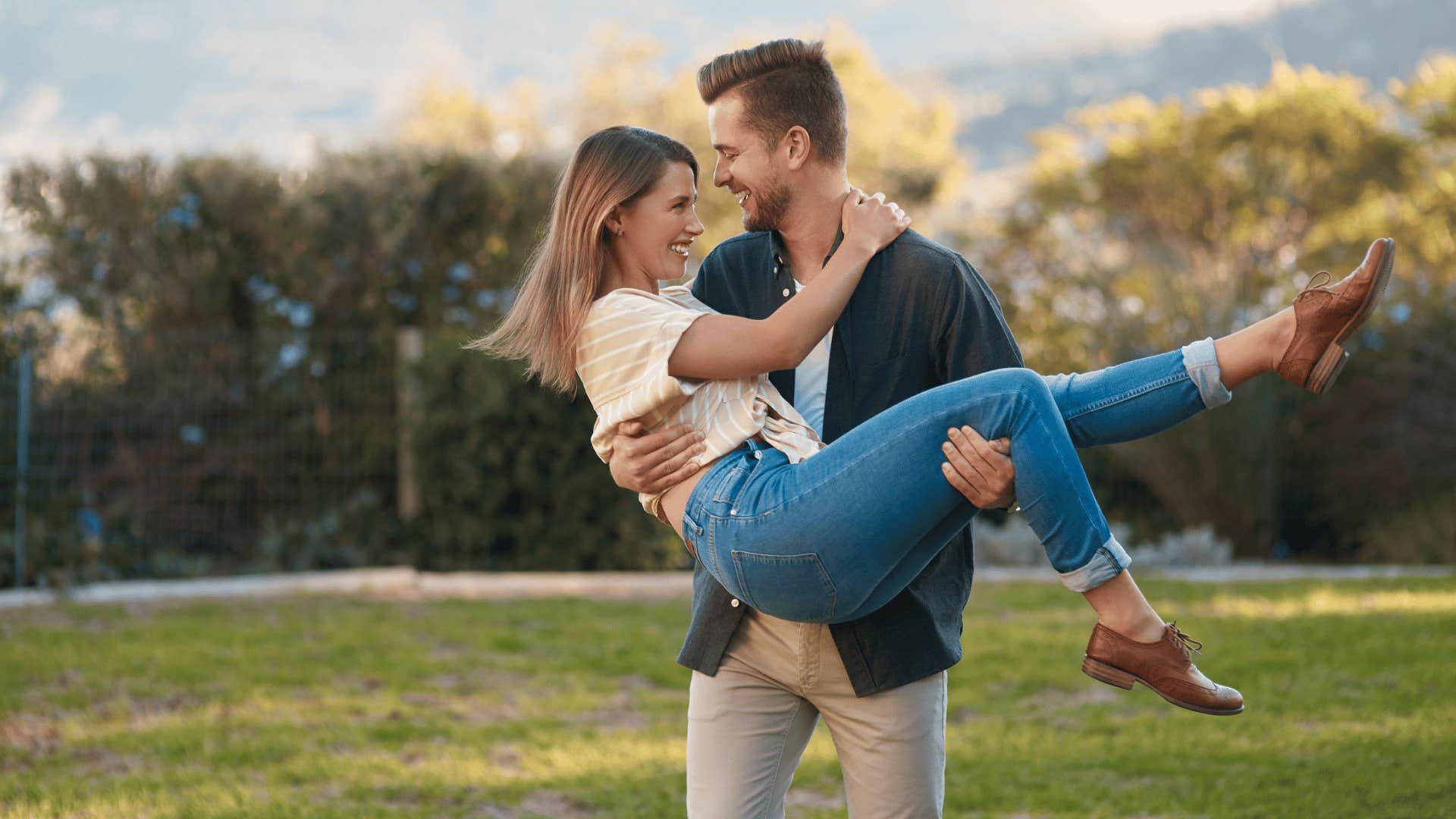 woman in mans arms smiling 