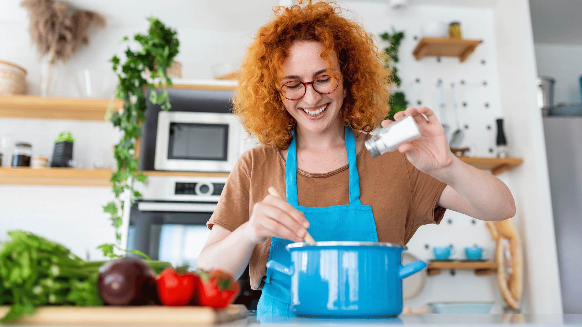 woman smiling while cooking