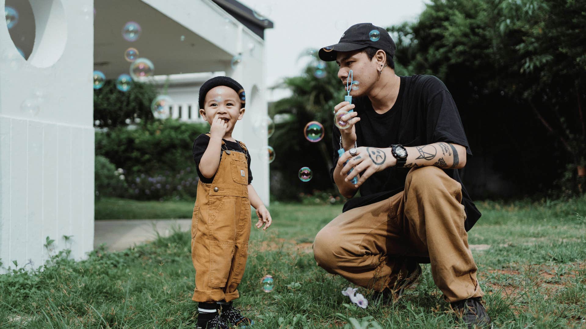 man blowing bubbles with boy