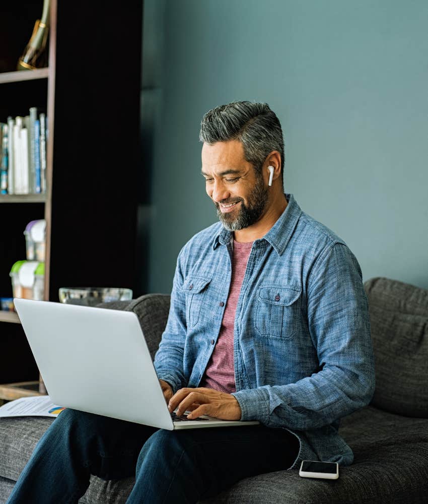 man happily working from the comfort of his couch