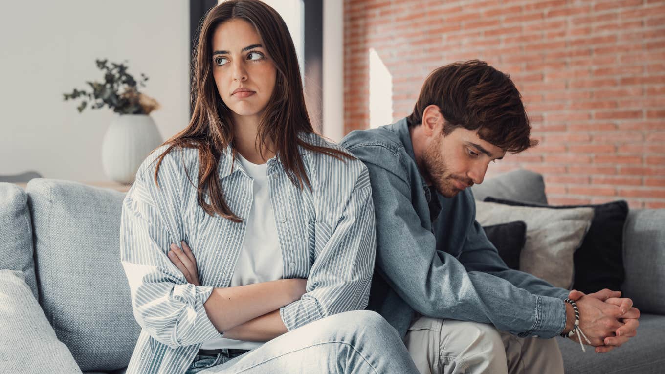 Man sitting behind his girlfriend looking upset.