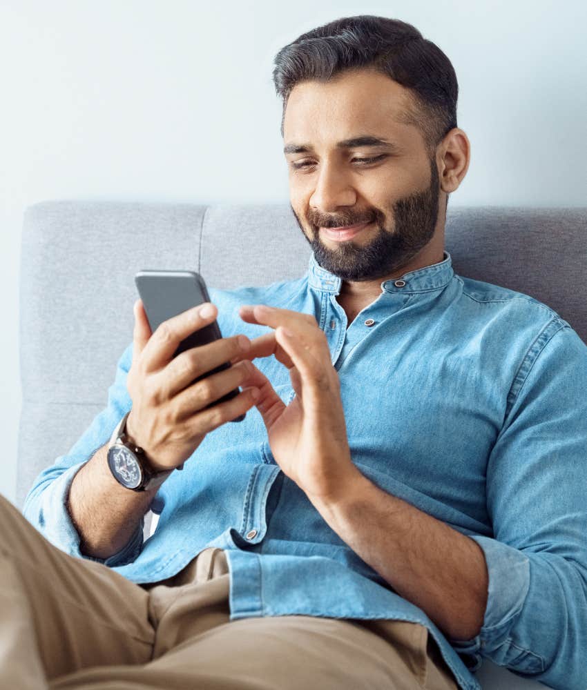 man flirting over text and smiling