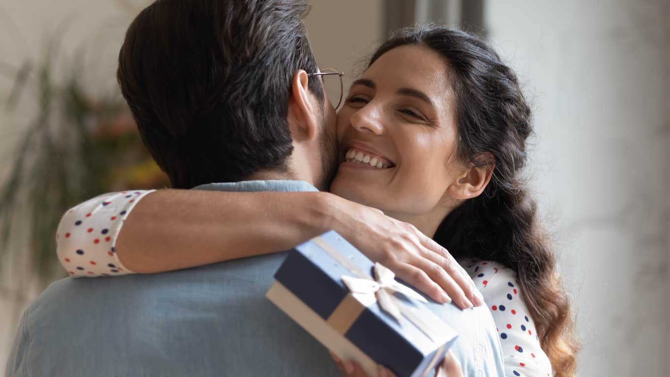 Girlfriend hugging man with his birthday present. 