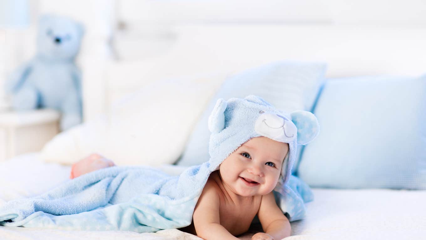 baby boy wrapped in bear towel on bed