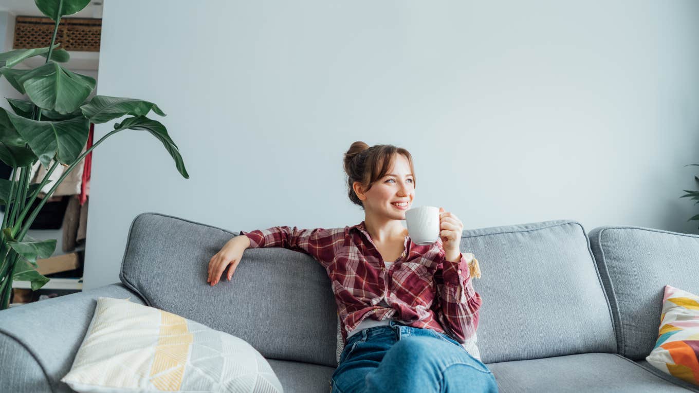 woman relaxing sitting on a couch with a cup of coffee