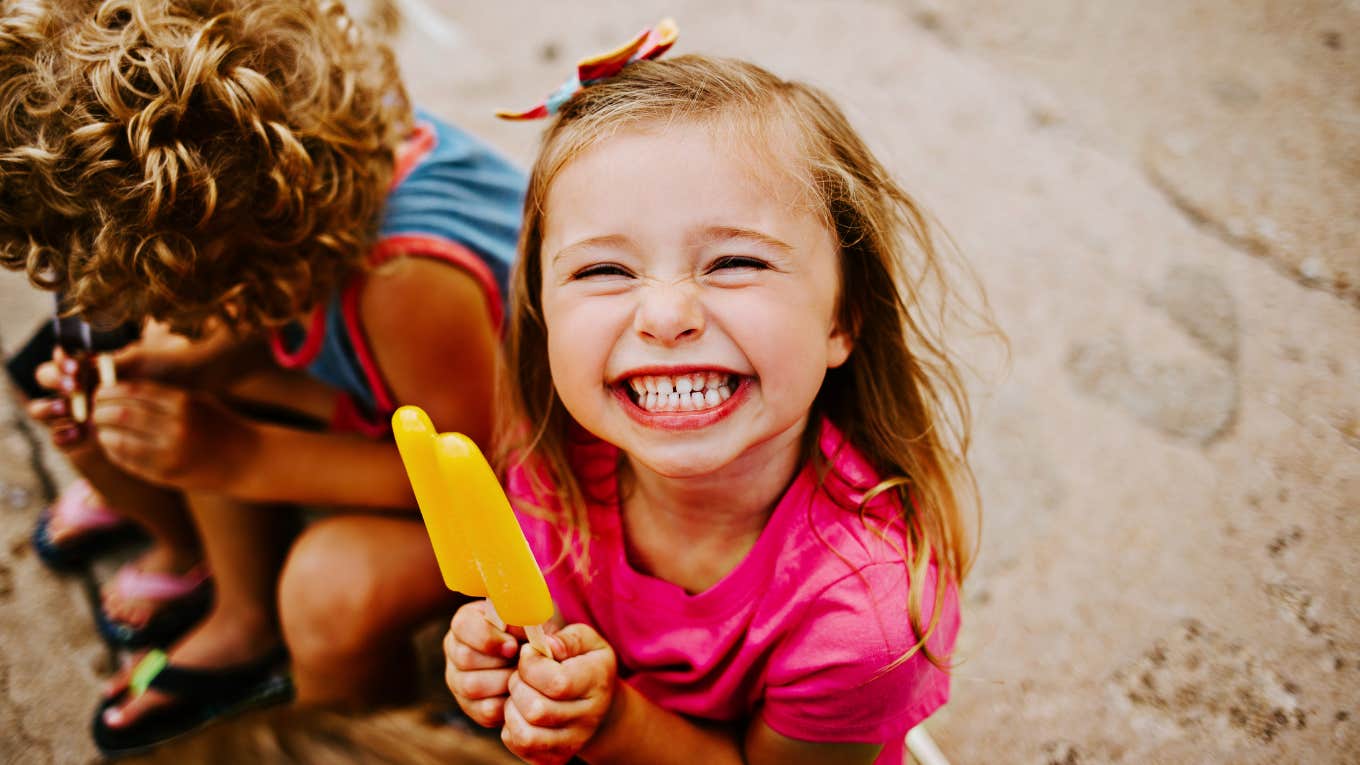 Young child happily eating a popsicle