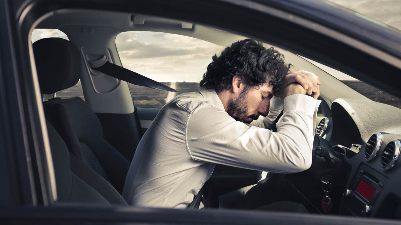 man sleeping at the wheel in car