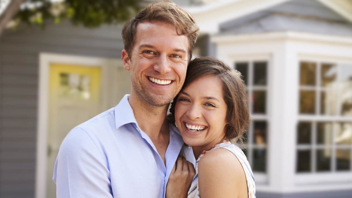 Couple isn't married, but making a mistake in front of a house