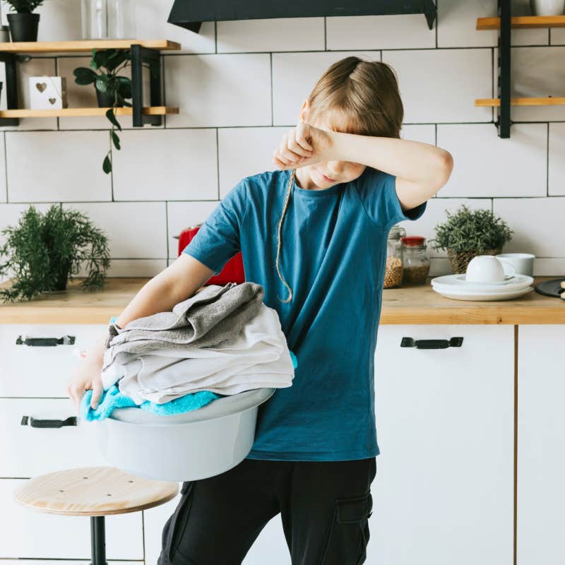 teen boy stressed while doing laundry