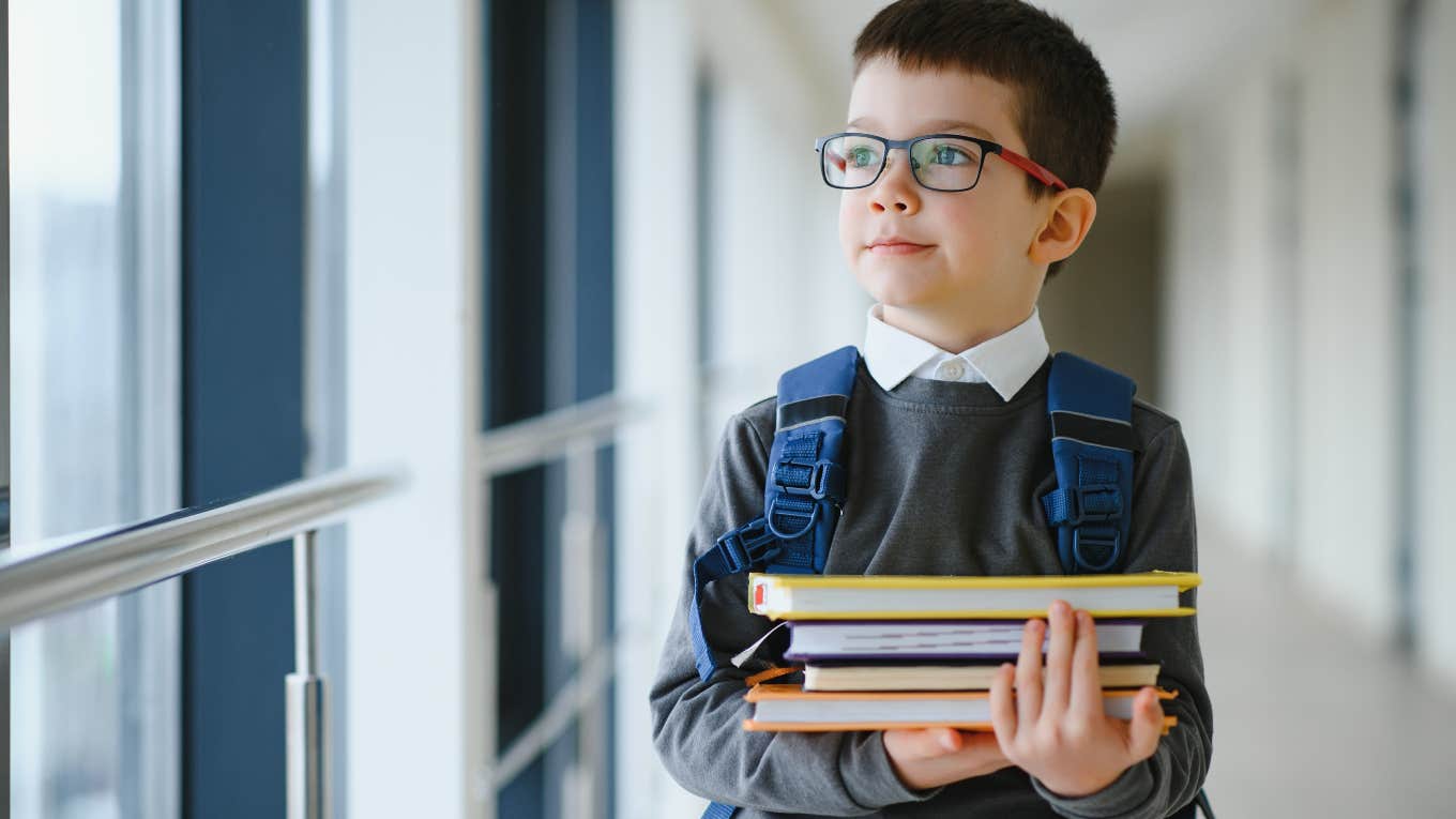 little boy with a backpack and books ready for school