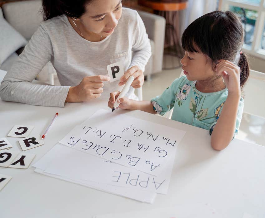 mom sitting down with daughter and teaching alphabet and phonetics