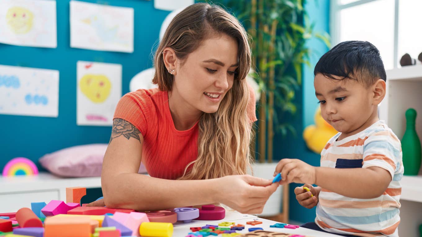 Woman at childcare facility playing with a toddler.