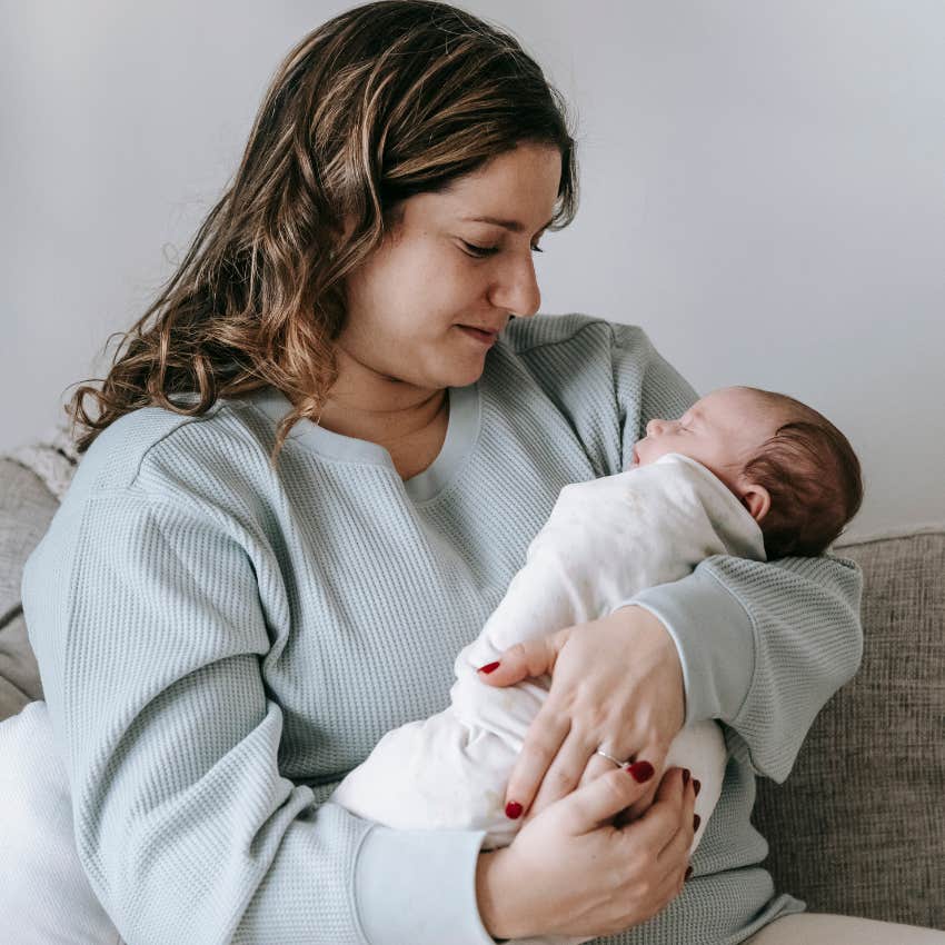 Mom thinking about motherhood holding her newborn baby.