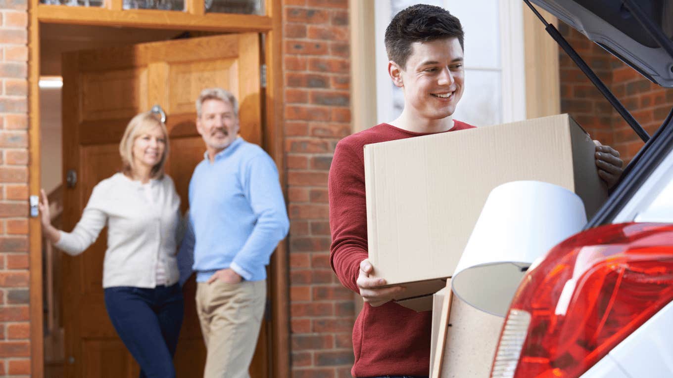 young man packing boxes in a car while parents watch