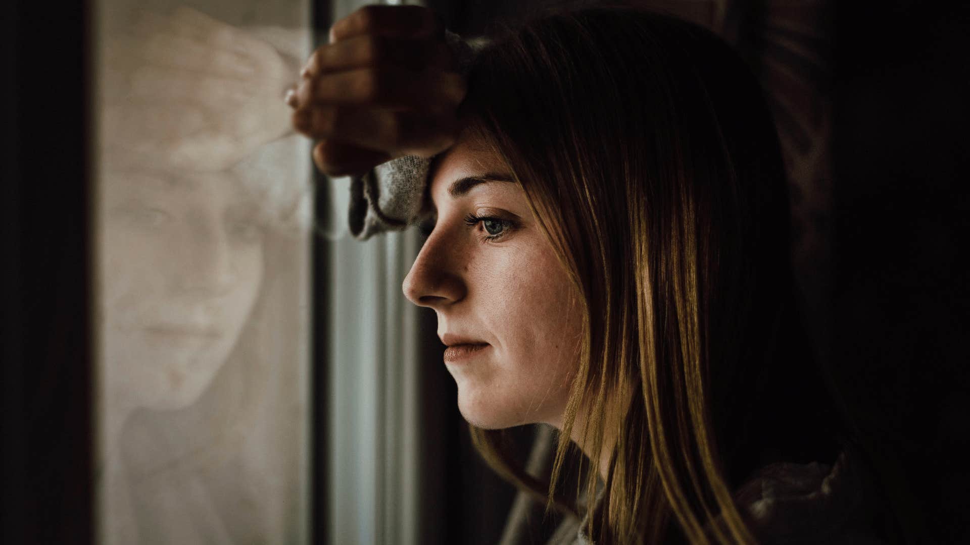 woman staring out window 