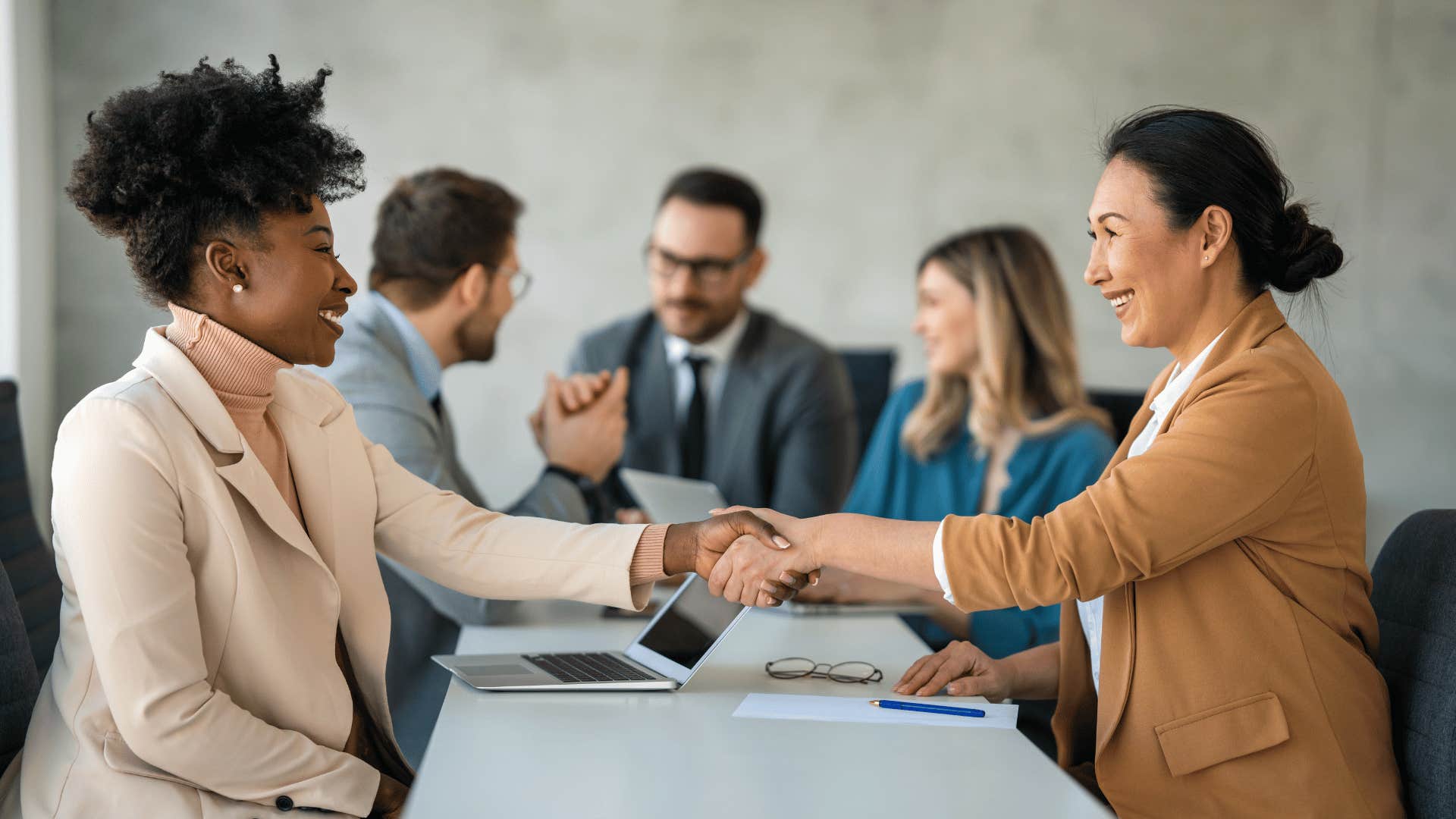 two female coworkers shaking hands