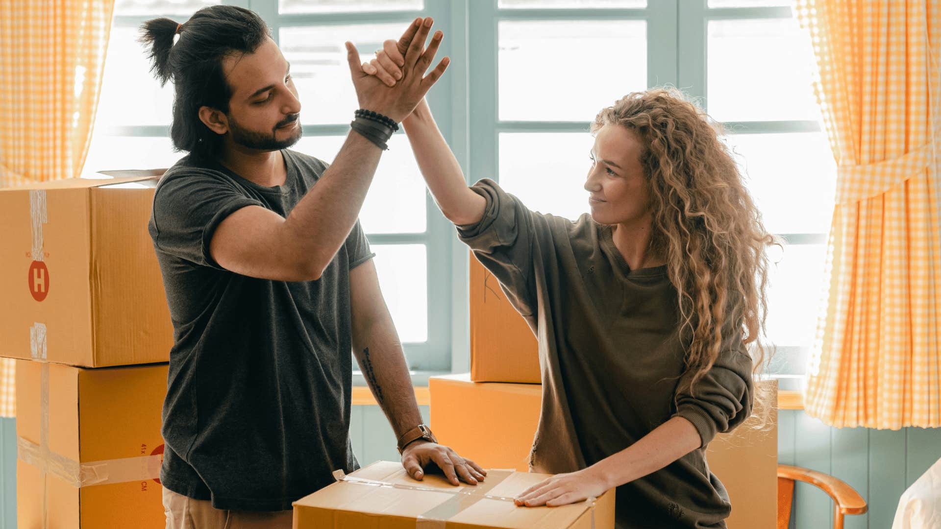 couple helping each other with moving boxes