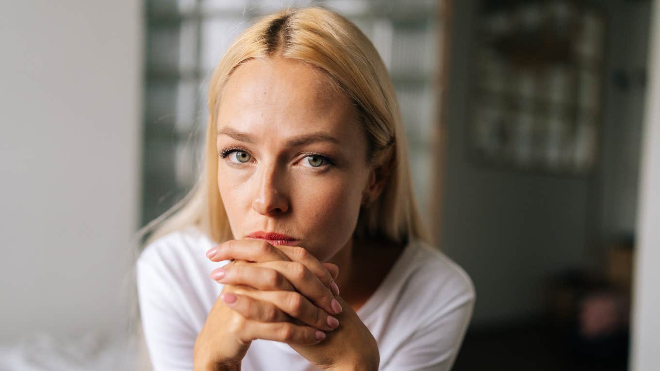 upset woman with hands crossed on face