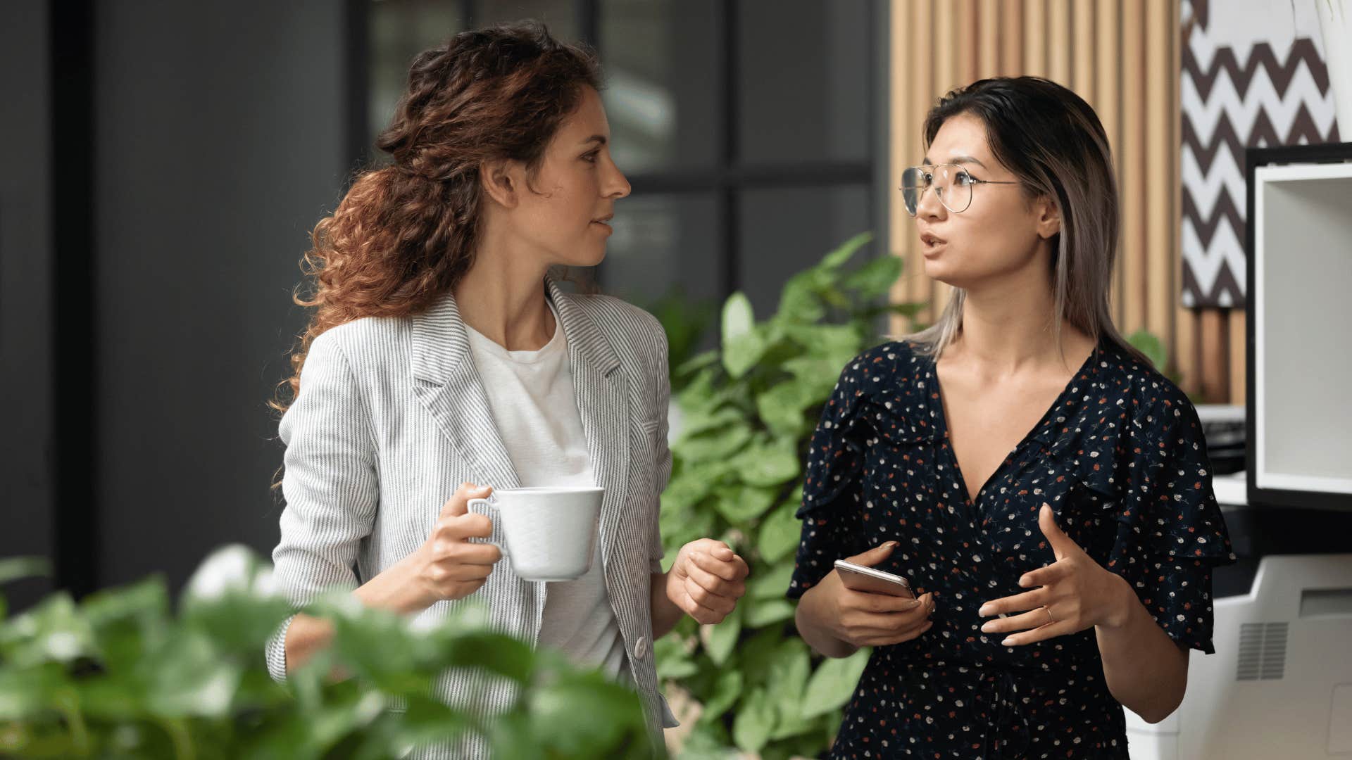 two coworkers discussing something while walking 