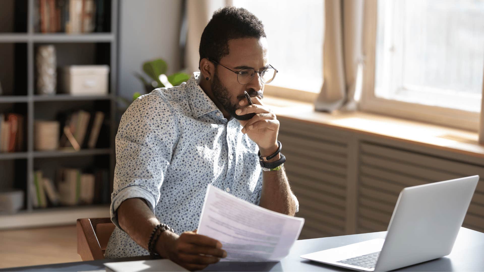 man thinking deeply while staring at laptop