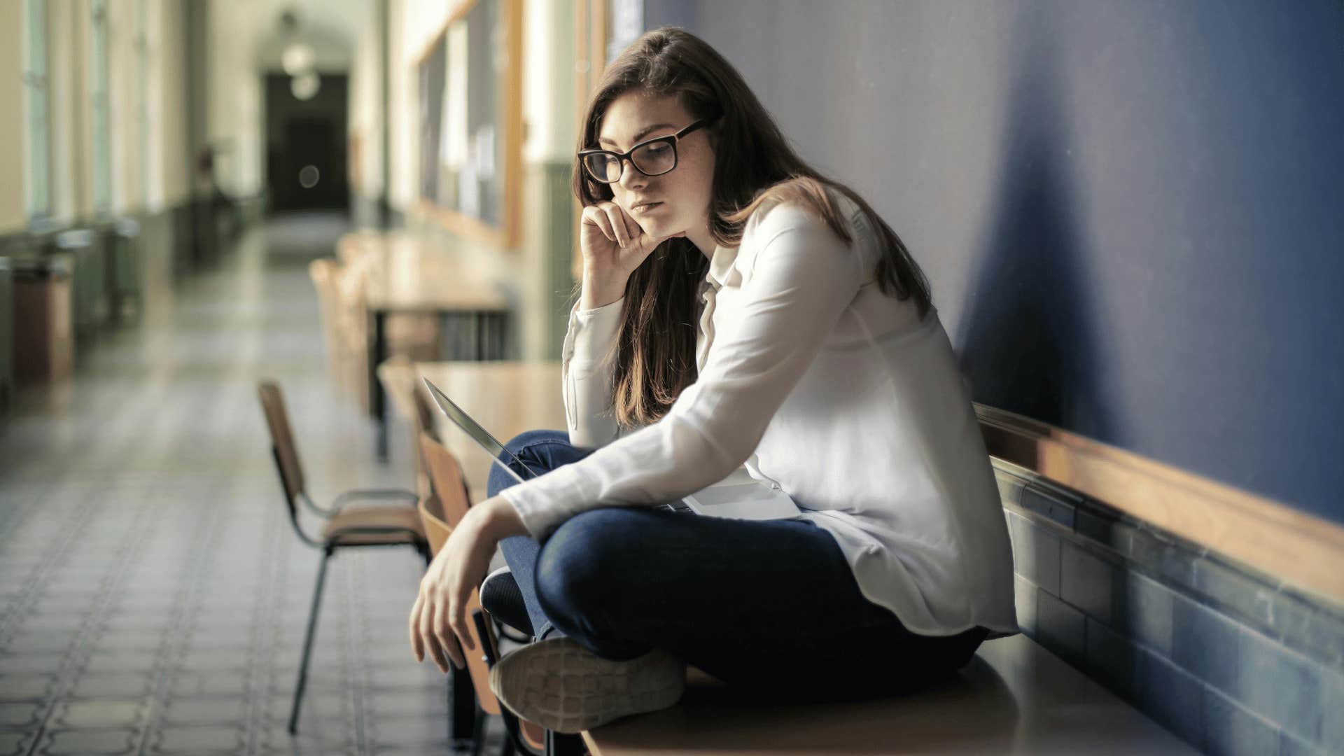 woman sitting alone looking upset