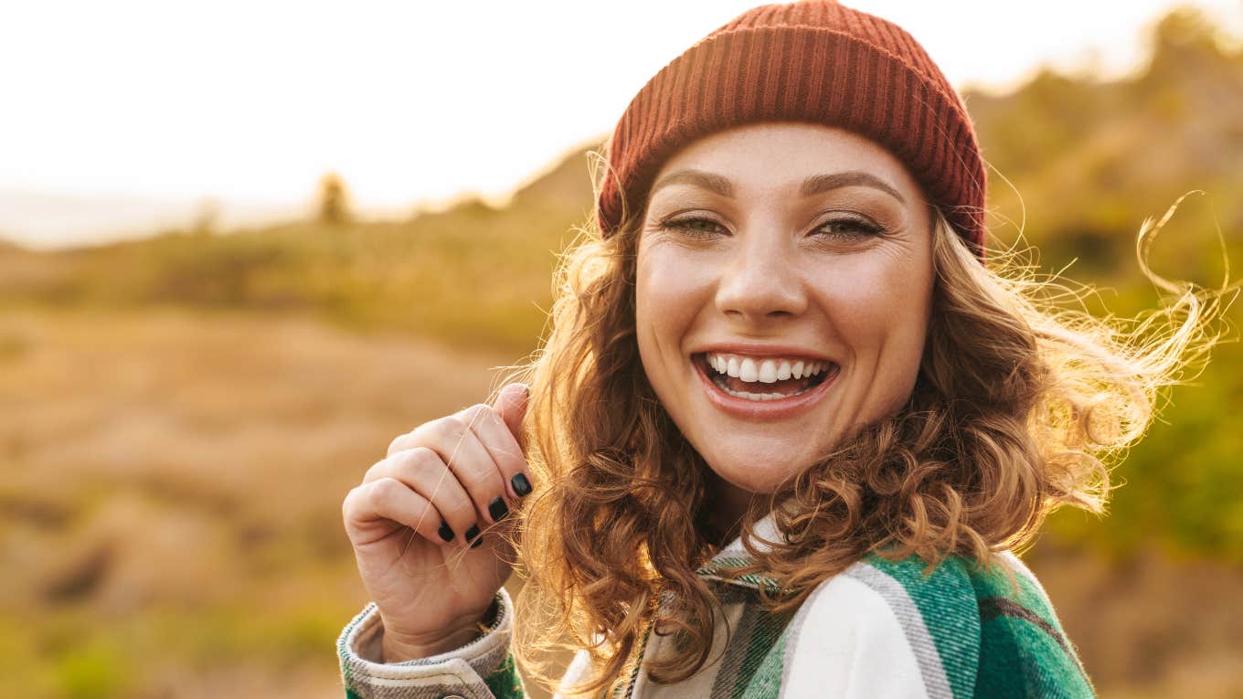 happy woman wearing a hat outdoors