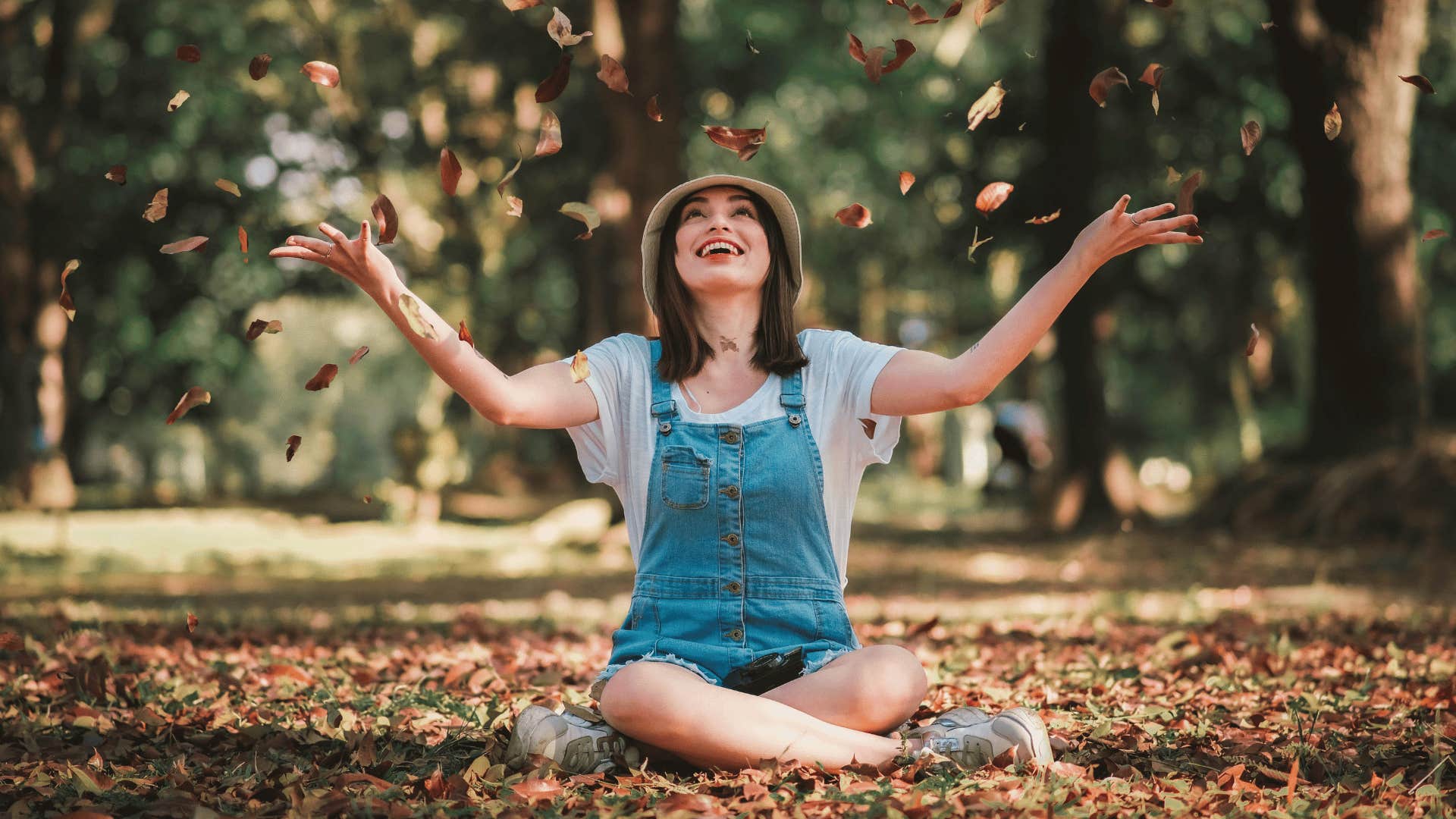 woman tossing leaves in air 