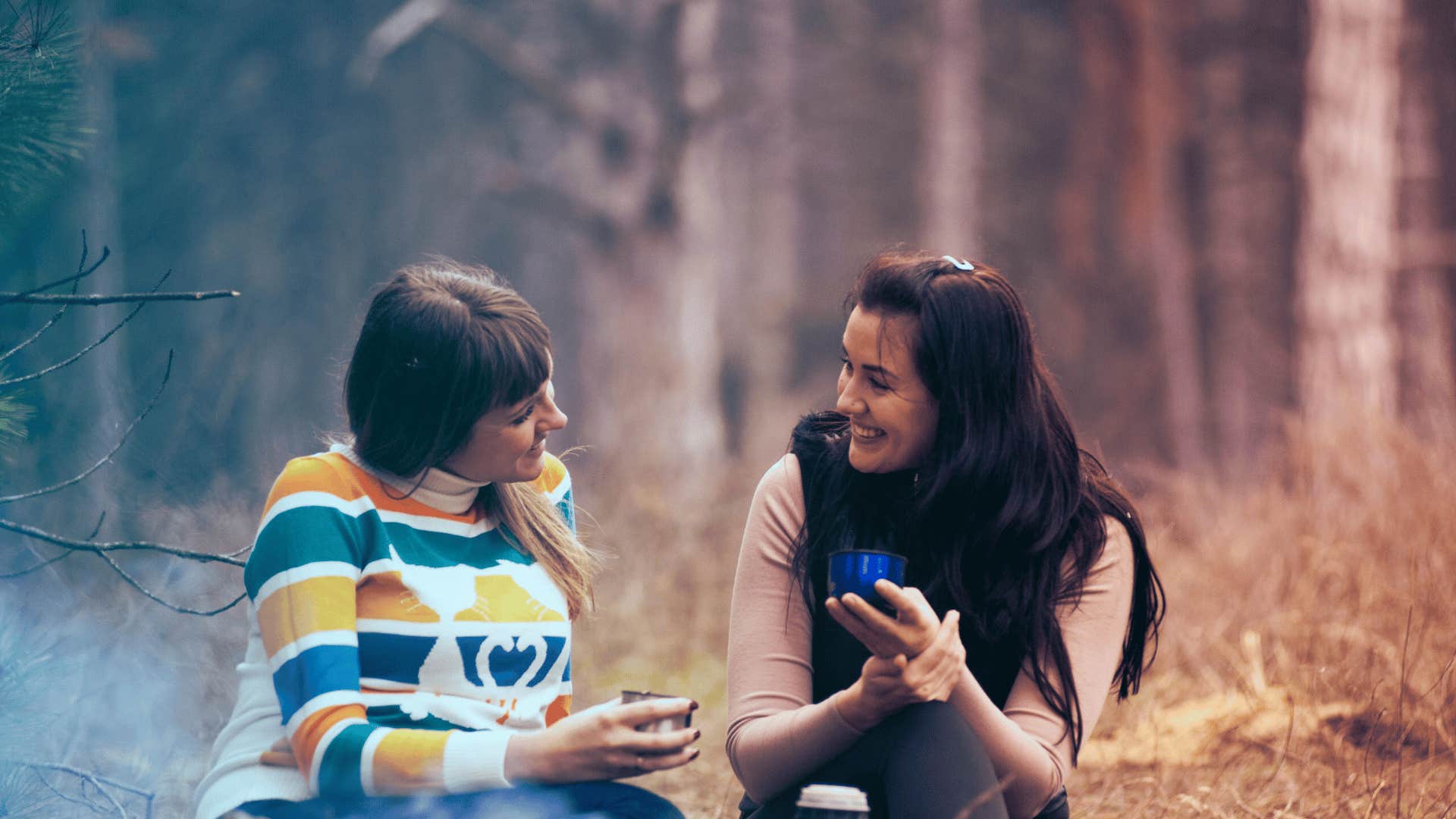 women camping outdoors focusing on their conversation