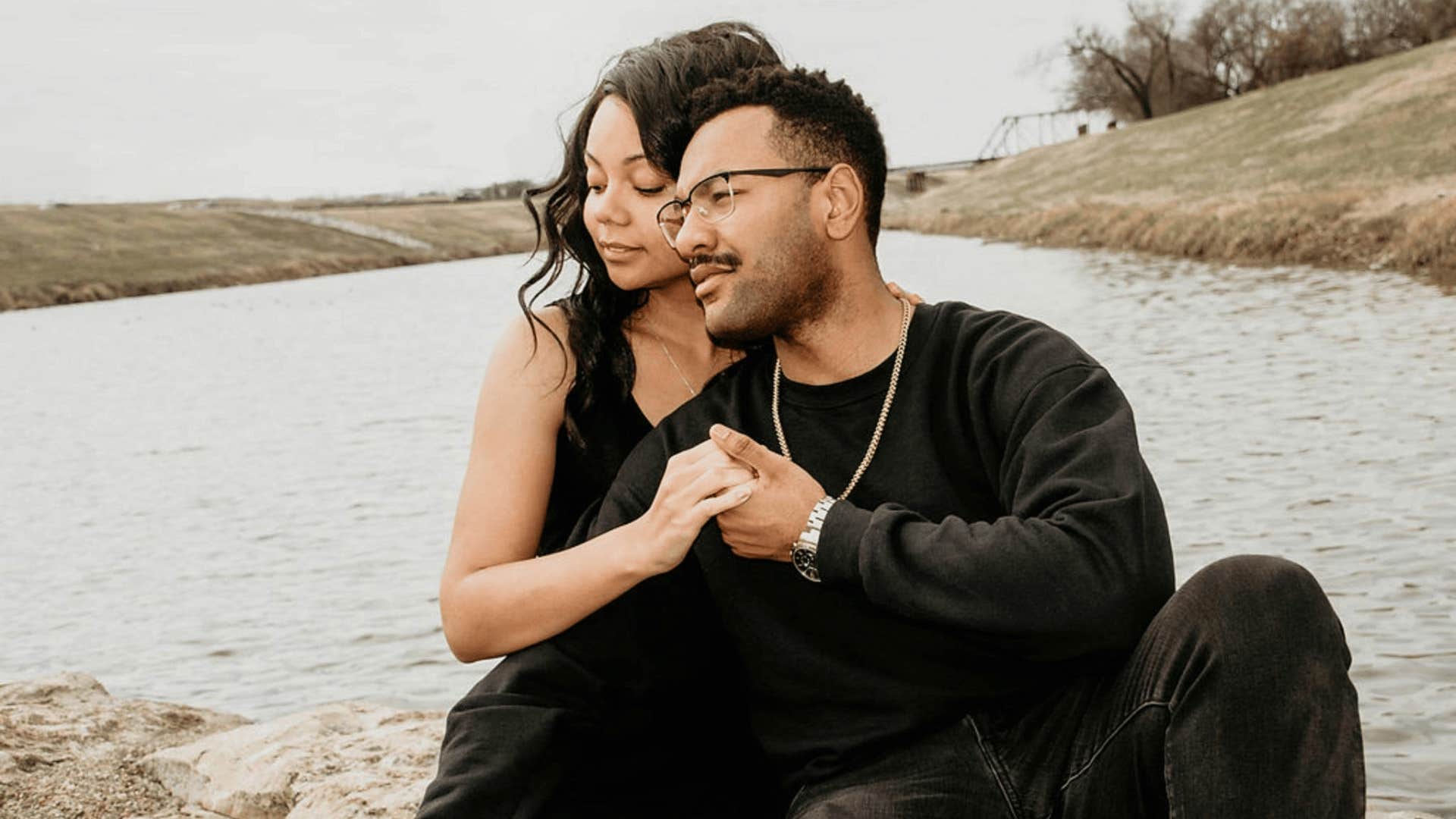 couple supporting each other by the water