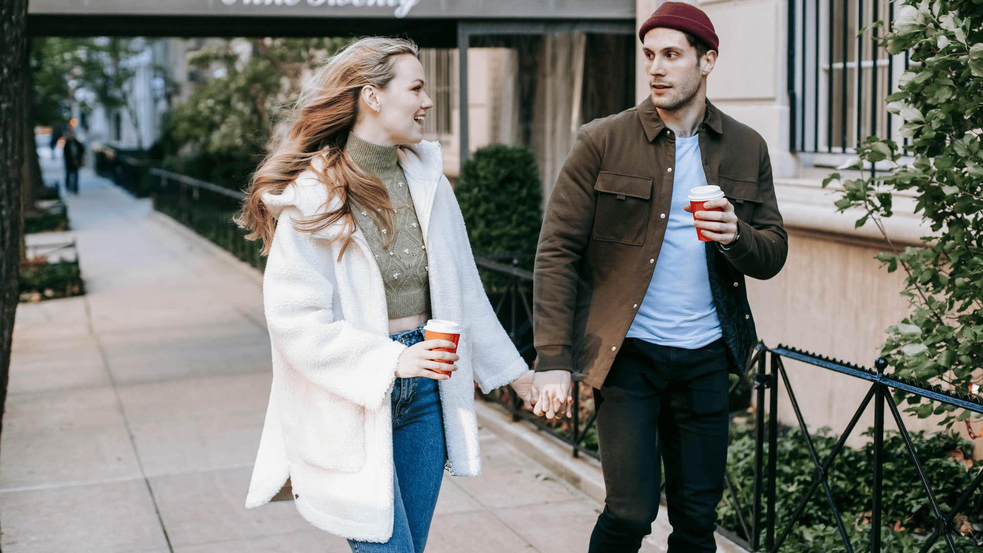 smiling couple holding hands as they walk