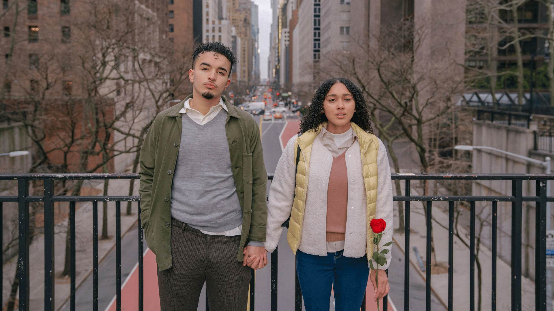 couple standing side by side on a bridge