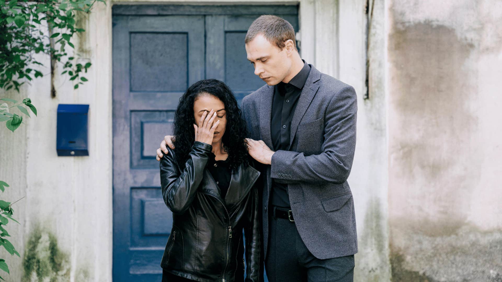 upset couple standing in front of door