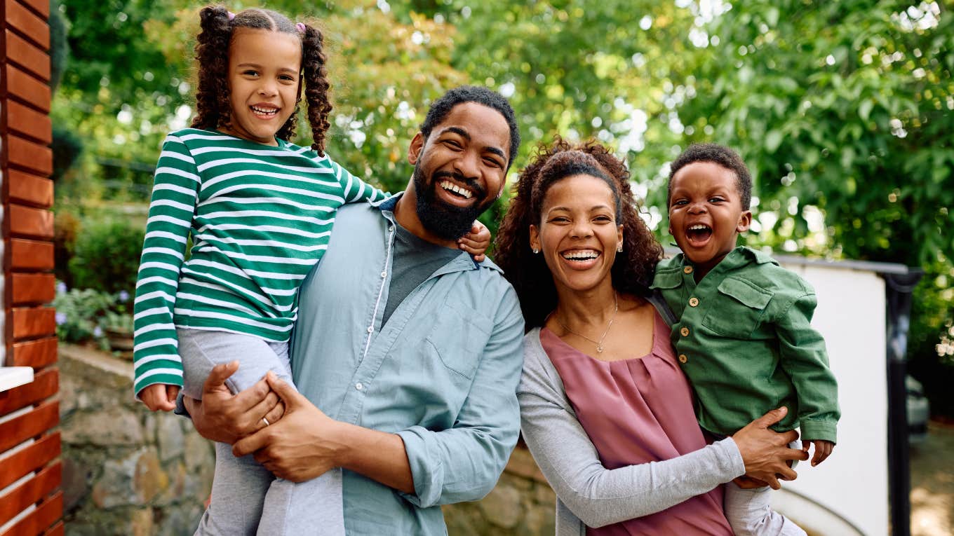 happy family smiling outside their home