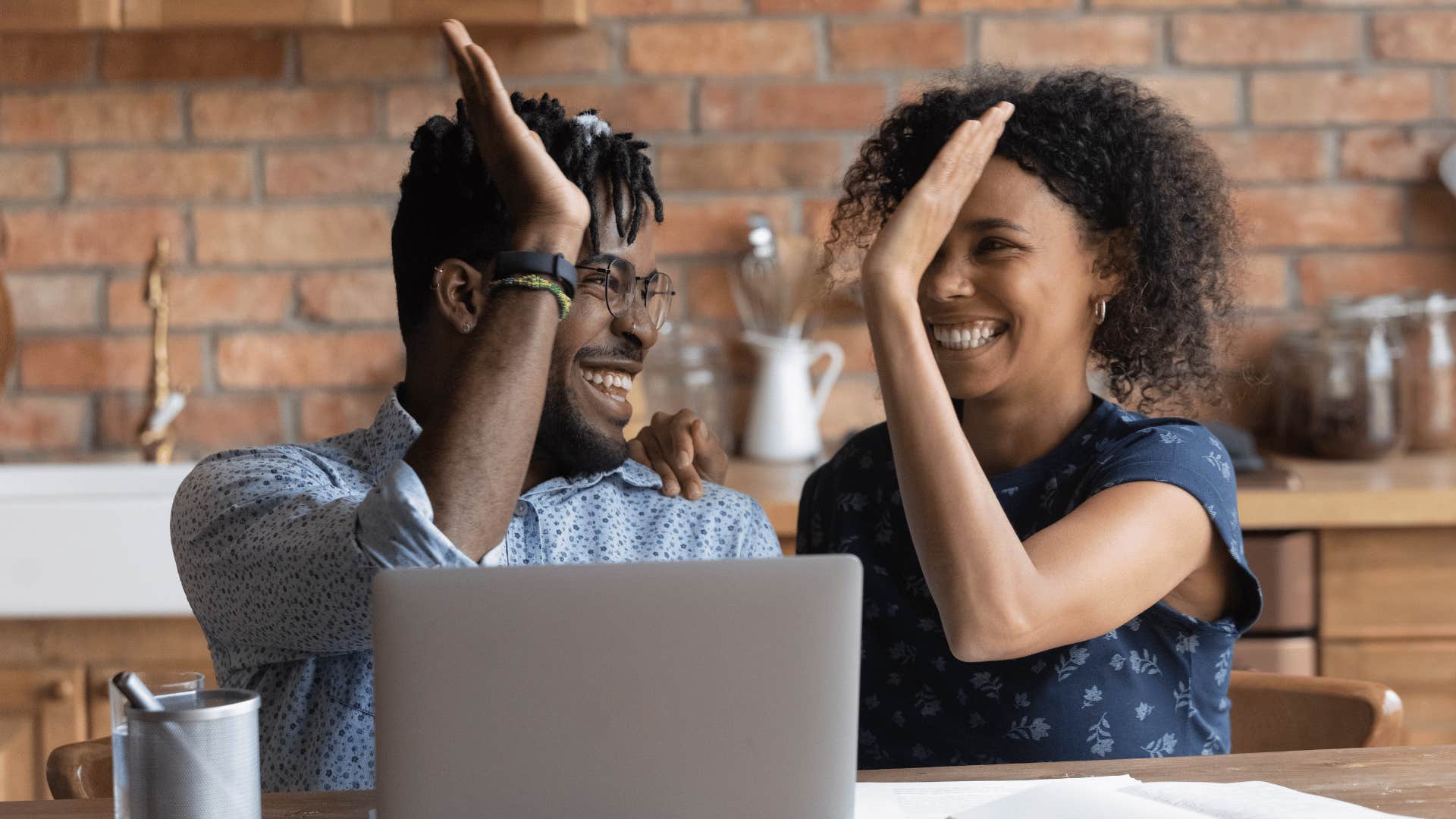 man and woman high fiving each other 