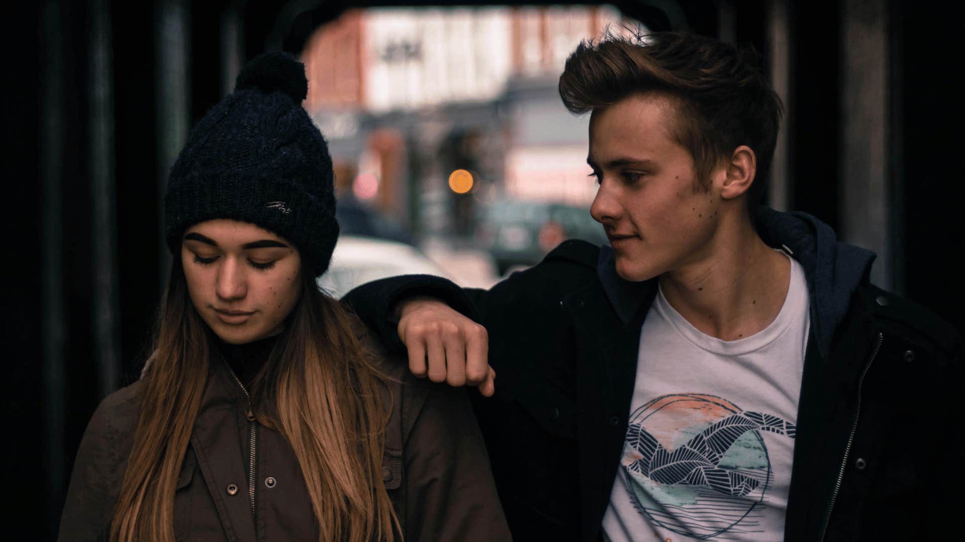 man comforting woman while walking 